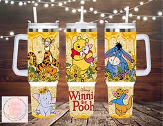 winnie the pooh and friends travel mugs with string lights on wooden table in background