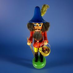 a nutcracker figurine with a beard and feather on it's head