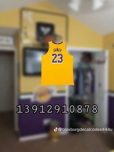 a basketball jersey hanging from the ceiling in a room with purple and yellow walls,