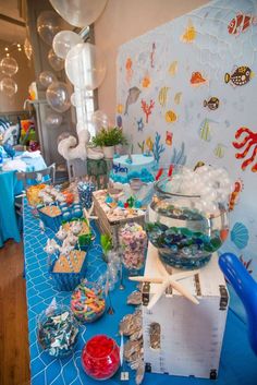 an ocean themed birthday party with balloons and food on the table in front of it