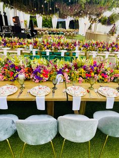 the tables are set up with plates and flowers on them for an outdoor wedding reception