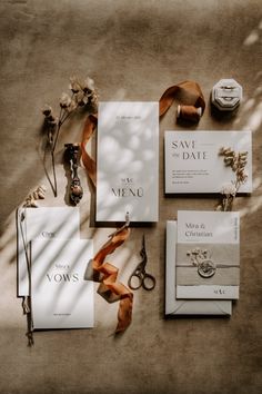 the wedding stationery is laid out on the floor next to some scissors and other items