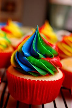 cupcakes decorated with colorful icing on a rack