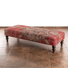 a red bench sitting on top of a tiled floor