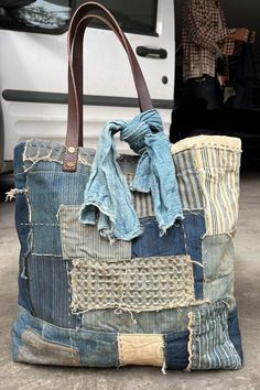 a large bag made out of old jeans and other fabric material is sitting on the ground