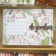 an open planner sitting on top of a desk next to some scissors and other crafting supplies