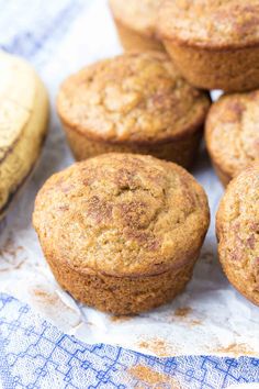 several muffins sitting on top of a blue and white napkin next to a banana