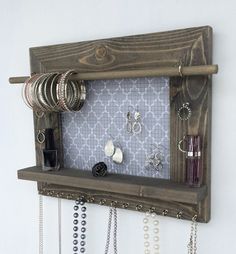 a wooden shelf with jewelry hanging from it's sides and an ad for amazon