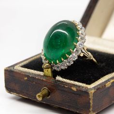 The Melinda ring is an authentic vintage design. This ring centers one natural cabochon cut emerald that weighs 18ctw approx. and is surrounded by 22 old mine cut diamonds of I color, VS2 clarity that weigh 1.30ctw. The stones are set in a platinum setting with details in 18k gold. Luxury Diamond Cabochon Jewelry, Luxury Platinum Cabochon Jewelry, Luxury Cabochon Diamond Ring In Fine Jewelry Style, Luxury Fine Jewelry Gemstone Ring, Luxury Exquisite Emerald Ring, Luxury Traditional Gemstones, Luxury Cabochon Dome Ring, Luxury Elegant Ring With Natural Stones, Luxury Fine Jewelry Ring With Center Stone