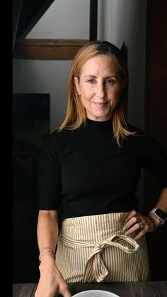 a woman standing in front of a plate of food