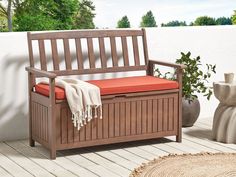 a wooden bench with an orange cushion on it