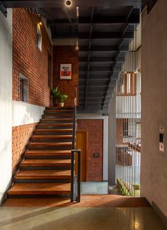 the stairs are made of wood and metal, with brick walls in the back ground