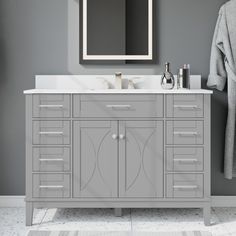 a bathroom vanity with two sinks and a towel hanging on the wall next to it