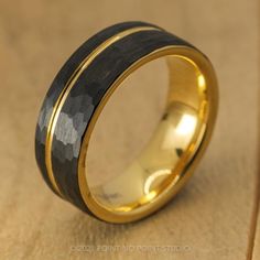 a black and gold wedding ring with an inlay