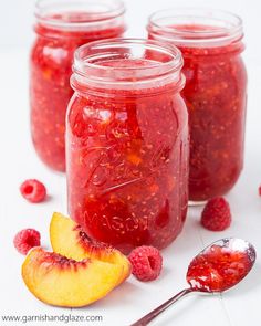 raspberry peach freeze jam in mason jars with spoons and fresh fruit on the side