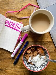 a cup of coffee next to an open notebook and a bowl of oatmeal