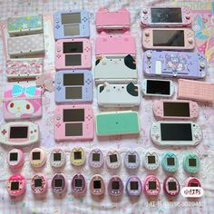 many different types of cell phones on a table with hello kitty stickers all over them