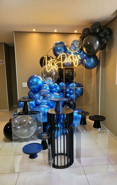 blue and black balloons are on display in a room