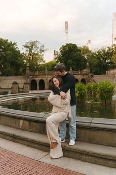 A couple posing for their elegant engagement photos in Central Park, NYC, with trees and fountains in the background. See tons of city couples photography at Central Park and Candid engagement photo ideas. Book Dani to capture your destination engagement in New York at daniparada.com. City Park Engagement Photos, Vintage Engagement Photoshoot, Photos For Couples, Nyc Engagement Photos, Nyc Engagement, Couples Book, Couples Play, Destination Engagement, Miami Wedding