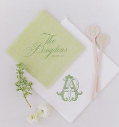 the wedding stationery is laid out on top of each other with two spoons