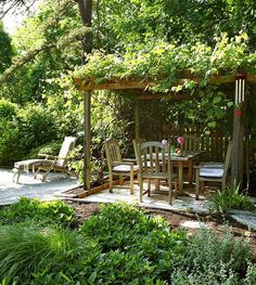 a wooden gazebo surrounded by lush green trees and shrubs, with chairs around it