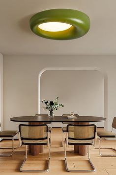 an oval table with four chairs around it in a room that has white walls and wood flooring