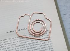 two pieces of metal sitting on top of an open book next to each other with words written in russian and english