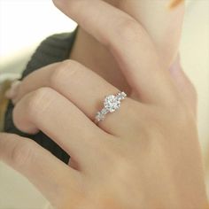 a woman's hand with a diamond ring on it