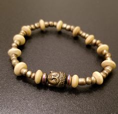 * Good luck buddha bracelet with gold and wood beads. *Buddha charm evokes calm and serene energies helping to create a tranquil space for setting intentions. *Good for meditation. *Bracelet is 17 Centimeters/ 6.69 inches on stretch cord. Spiritual Gold Bracelets With Wooden Beads, Spiritual Gold Bracelet With Wooden Beads, Spiritual Stretch Bracelet With Wooden Beads For Meditation, Spiritual Wooden Beads Stretch Bracelet For Meditation, Spiritual Wooden Beads Stretch Bracelet For Healing, Handmade Gold Stretch Bracelet For Meditation, Gold Bracelets With Wooden Beads For Healing, Gold Beaded Bracelets For Meditation, Buddha Bracelets