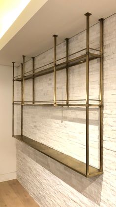 a white brick wall with gold metal shelves