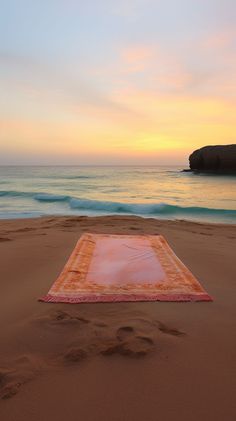 a blanket laying on top of a sandy beach