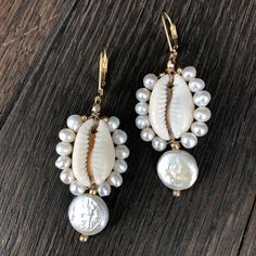 Tiny faux pearl trimmed cowry shells with freshwater coin pearl drop. Gold filled lever back 2” drop Summer Pearl Drop Earrings, Pearl Shell Drop Earrings With Pearl Drop Detail, Elegant White Cowrie Shell Jewelry, Dangle Pearl Drop Shell Earrings, Shell-shaped Pearl Earrings With Pearl Charm, Dangle Shell Earrings With Pearl Drop, Pearl Drop Dangle Shell, Summer Pearl Drop Dangle Earrings, Pearl Shell Earrings With Pearl Charm