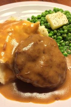 a white plate topped with mashed potatoes and gravy covered in gravy