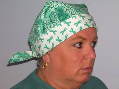 a woman wearing a green and white bandana with scissors on it's head