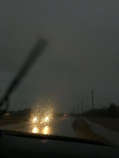 the rain is coming down on cars driving in the dark