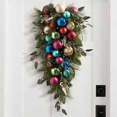 a door decorated with christmas ornaments and greenery