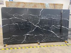 black and white marble with yellow lines on the floor next to it in a warehouse