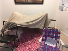 there is a covered table and chair in the room with it's cover on