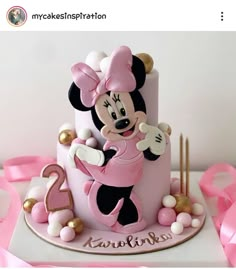 a minnie mouse cake with pink and gold decorations