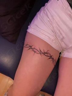 a woman's leg with barbed wire tattoo on it