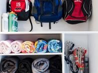 two white shelves filled with backpacks and sports gear