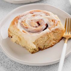 a cinnamon roll on a plate with a fork