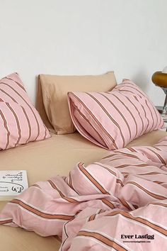 a bed covered in pink and brown striped sheets