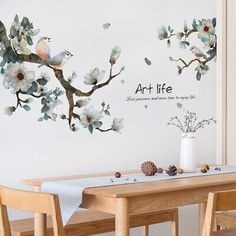 a dining room table with two chairs and a wall mural behind it that says art life