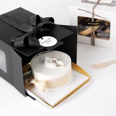 an open black box with a white cake inside