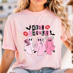 a woman wearing a pink t - shirt with three ghostes on it and the words mean