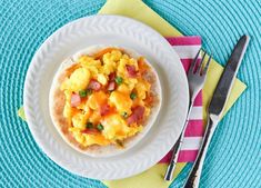 an omelet with ham and cheese is on a plate next to a fork