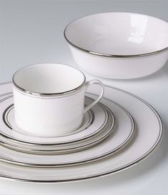 a white dinner set with silver trimmings