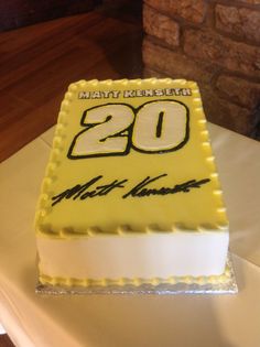 a yellow and white cake with the number 20 on it is sitting on a table