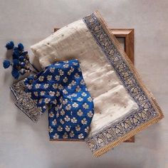 three pieces of cloth with blue and white designs are on a wooden frame next to each other